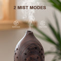 Close-up of the dark wood star diffuser demonstrating 2 mist modes: Continuous and Intermitten (Intermittent) for customized aroma intensity.